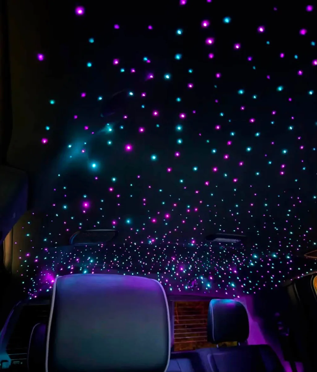 Starlight headliner installed in a vehicle cabin, purple and cyan fiber-optic stars across the roof